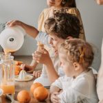 A family bonding over making fresh orange juice at home, enjoying quality time together.
