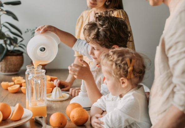 A family bonding over making fresh orange juice at home, enjoying quality time together.